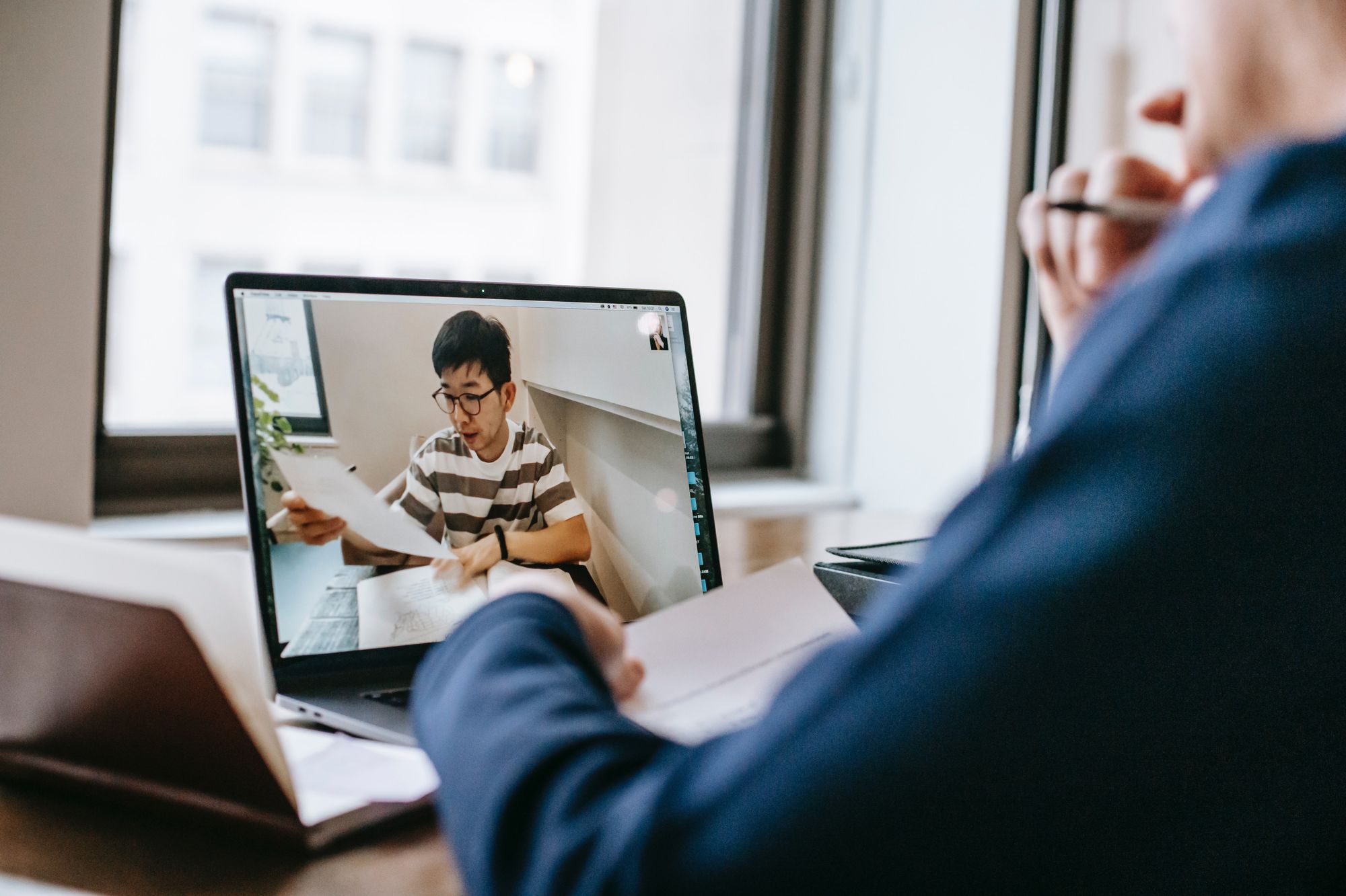 a man helps his student over video call